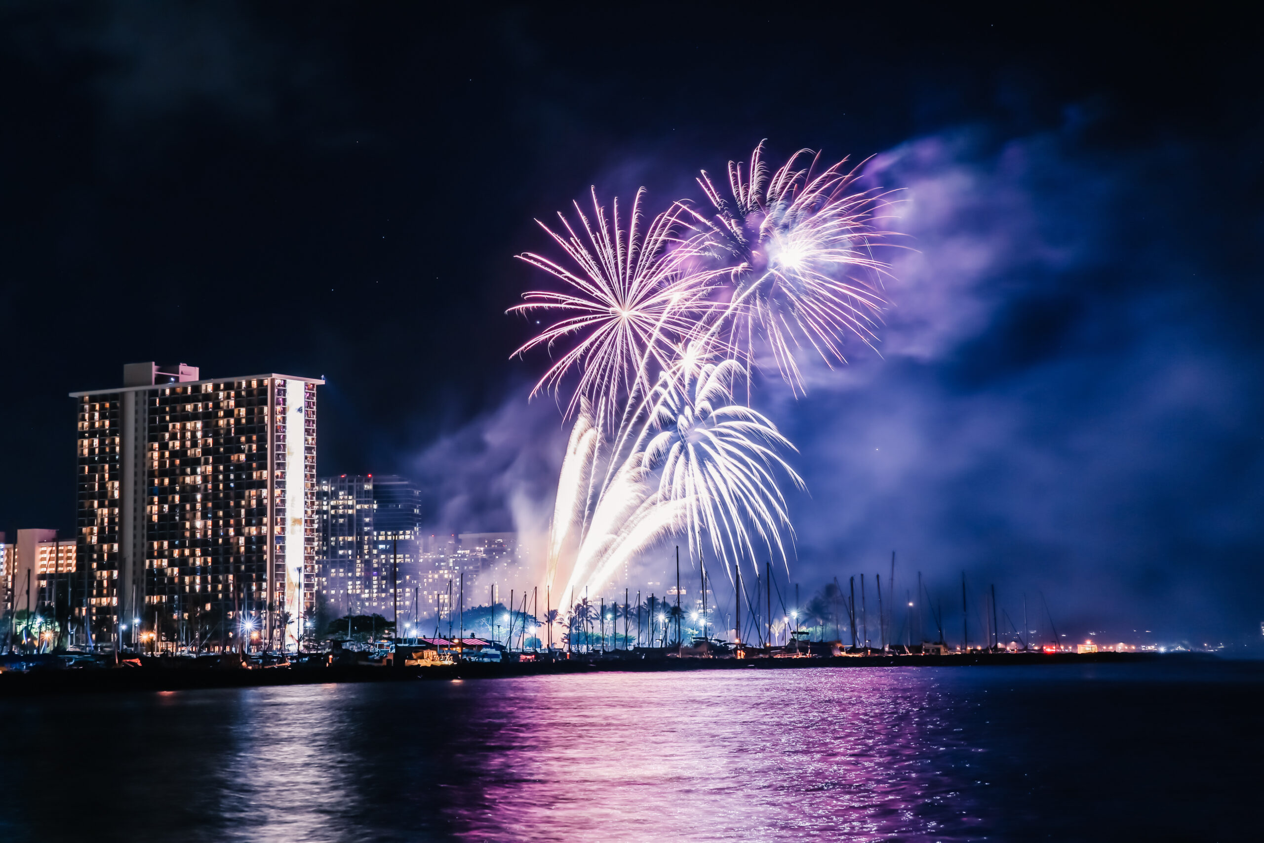 Fireworks lighting up the sky above Waikiki Beach, creating a vibrant and dazzling display.