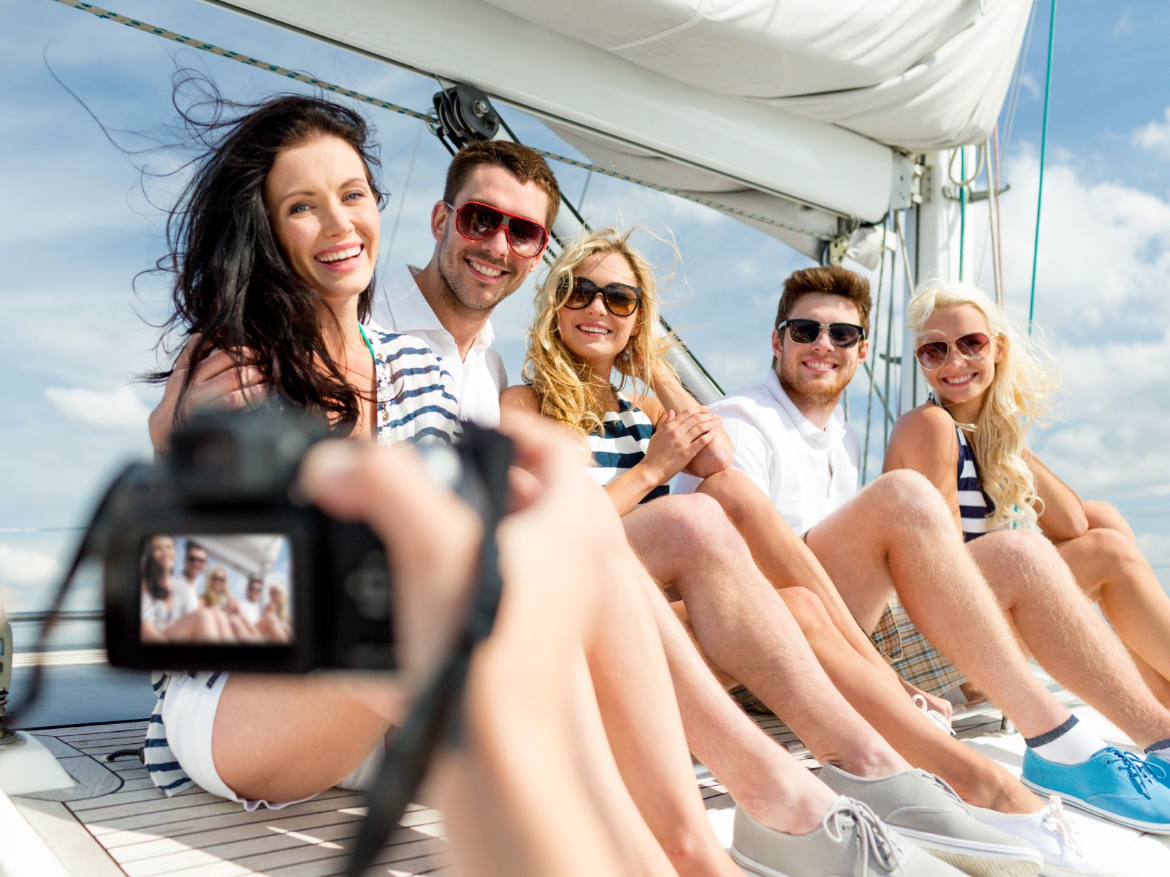 A camera capturing a group of people seated on a boat, enjoying the view and camaraderie.